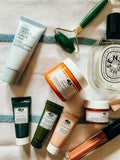 Skincare bottles and jade roller on towel
