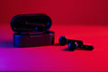 Black and blue wireless earbuds with red accents