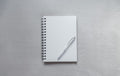 White notebook with pen overhead view